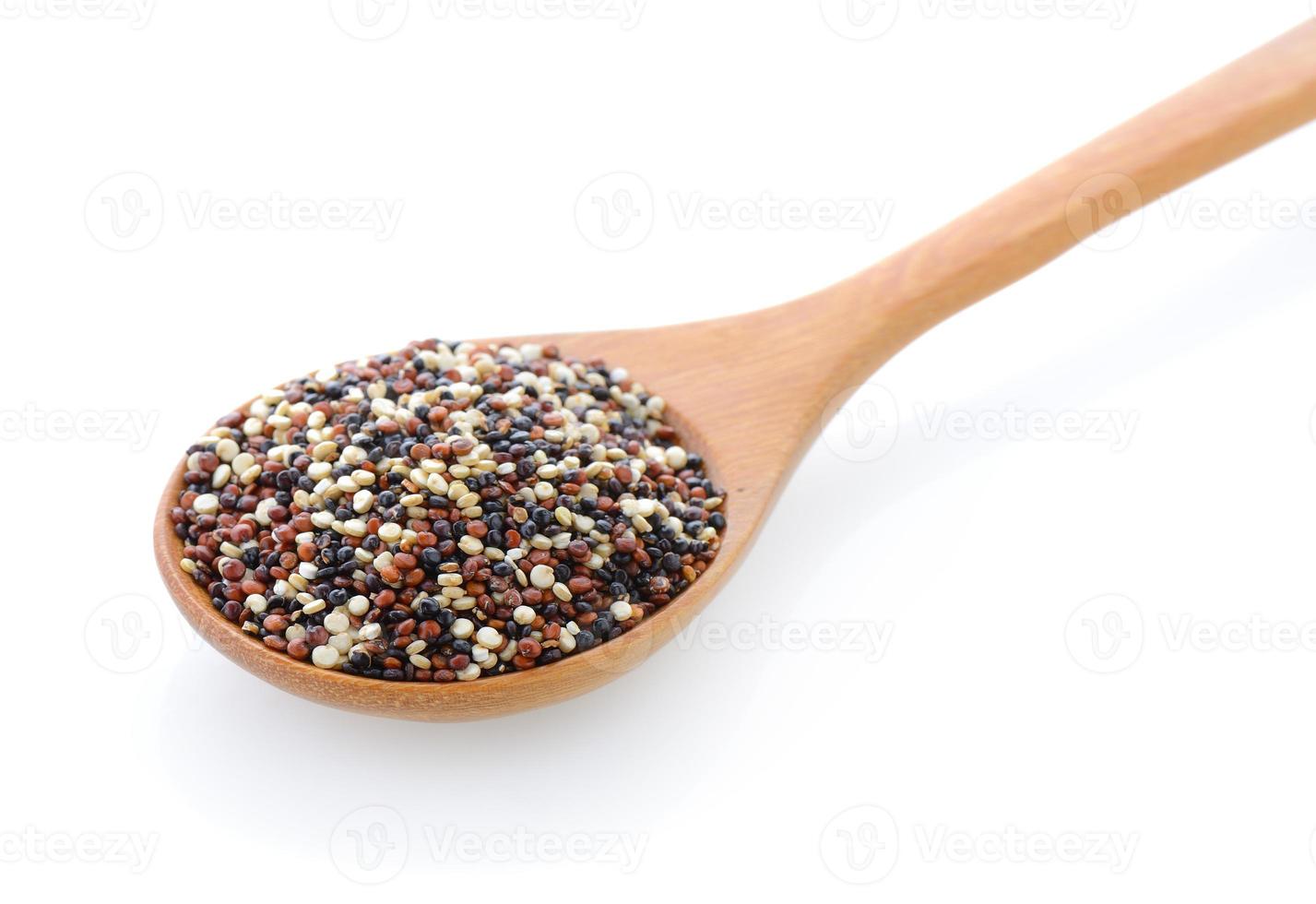 semi di quinoa in cucchiaio di legno su sfondo bianco foto