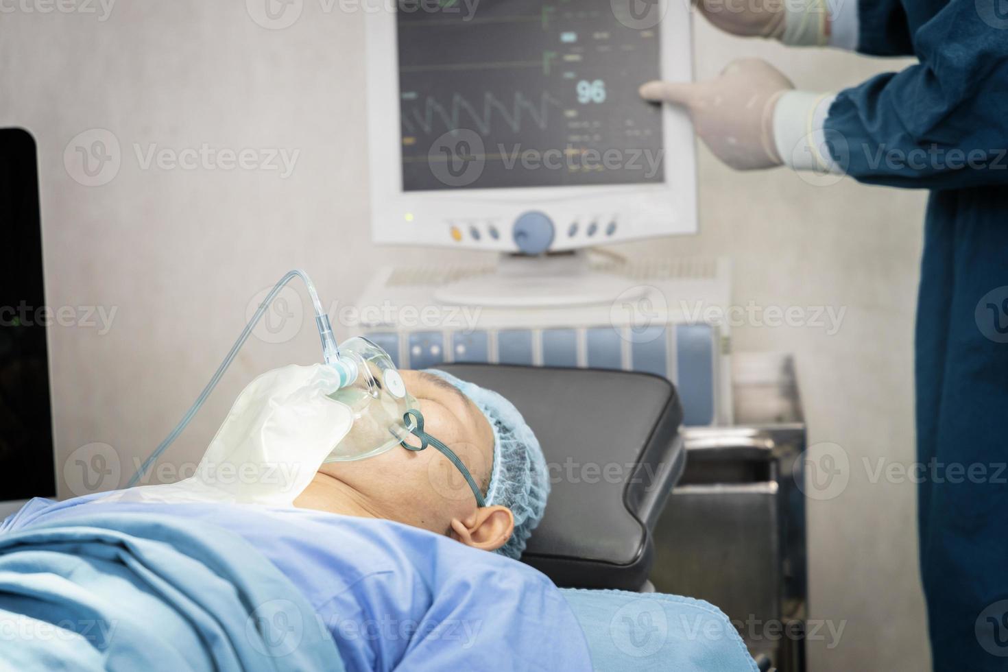 l'assistente chirurgo ha messo il paziente su una maschera di ossigeno-ventilatore in preparazione per l'intervento chirurgico foto