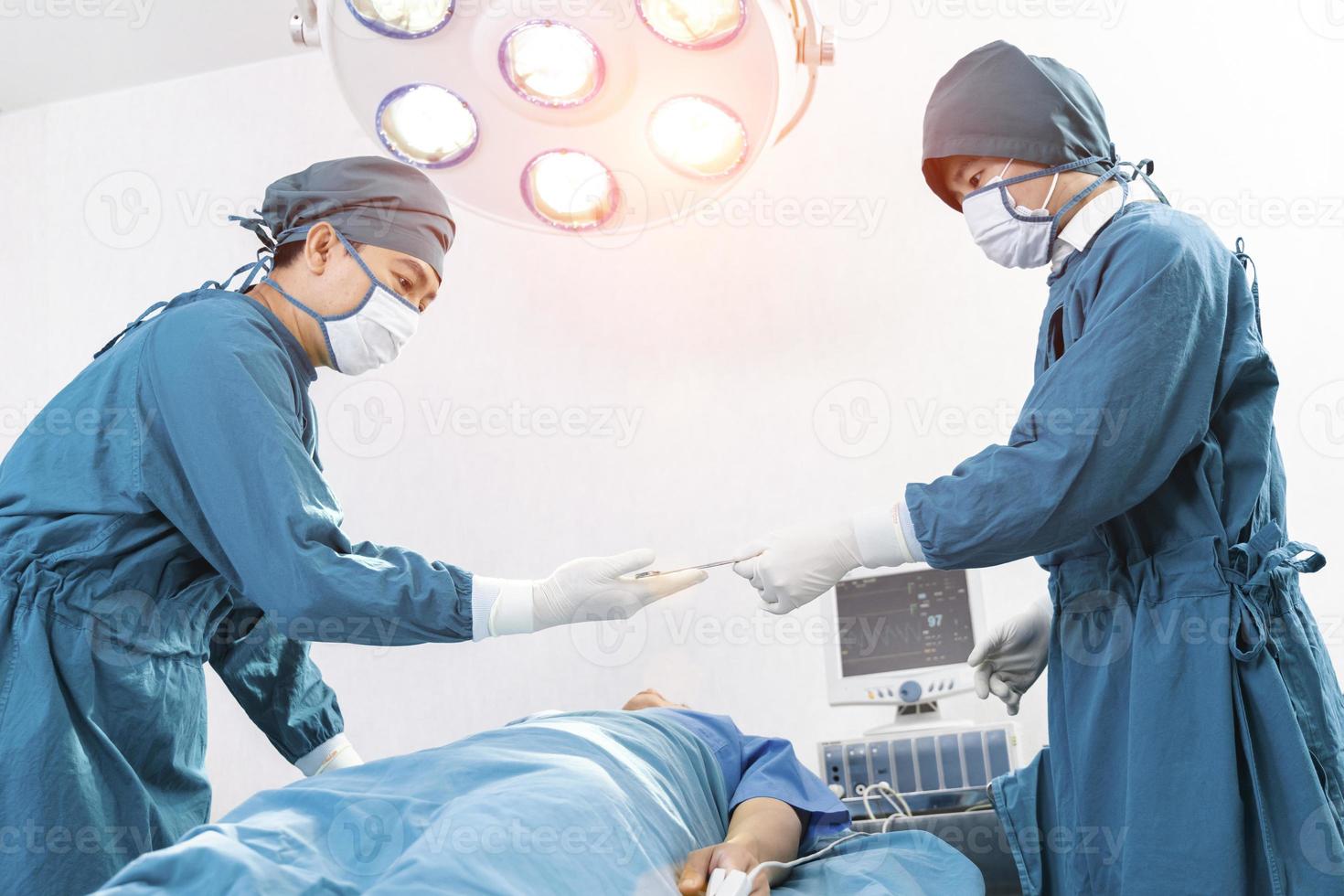l'assistente distribuisce gli strumenti ai chirurghi durante l'operazione. concetto di chirurgia e emergenza foto