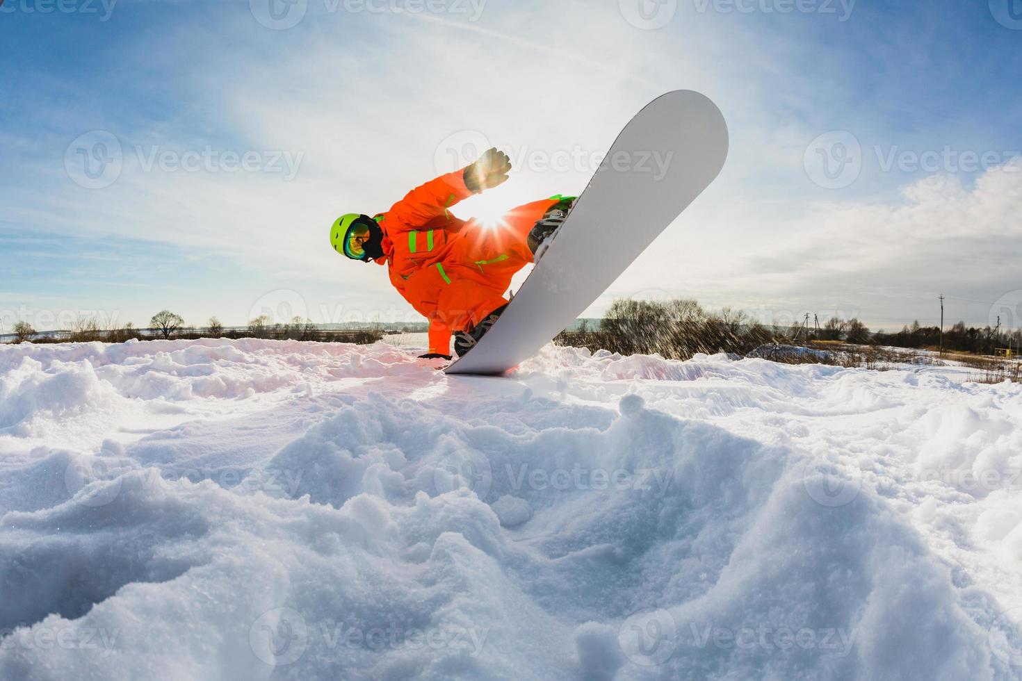 snowboarder che fa un trucco sulla pista da sci foto