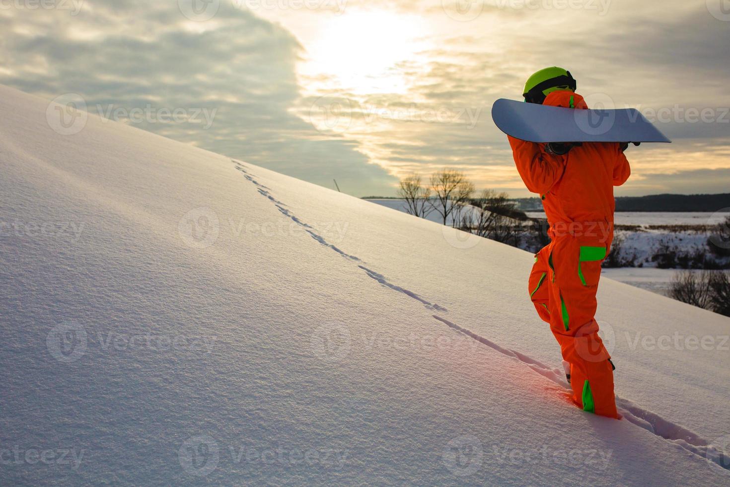 snowboarder che si arrampica in cima alla pista da sci foto