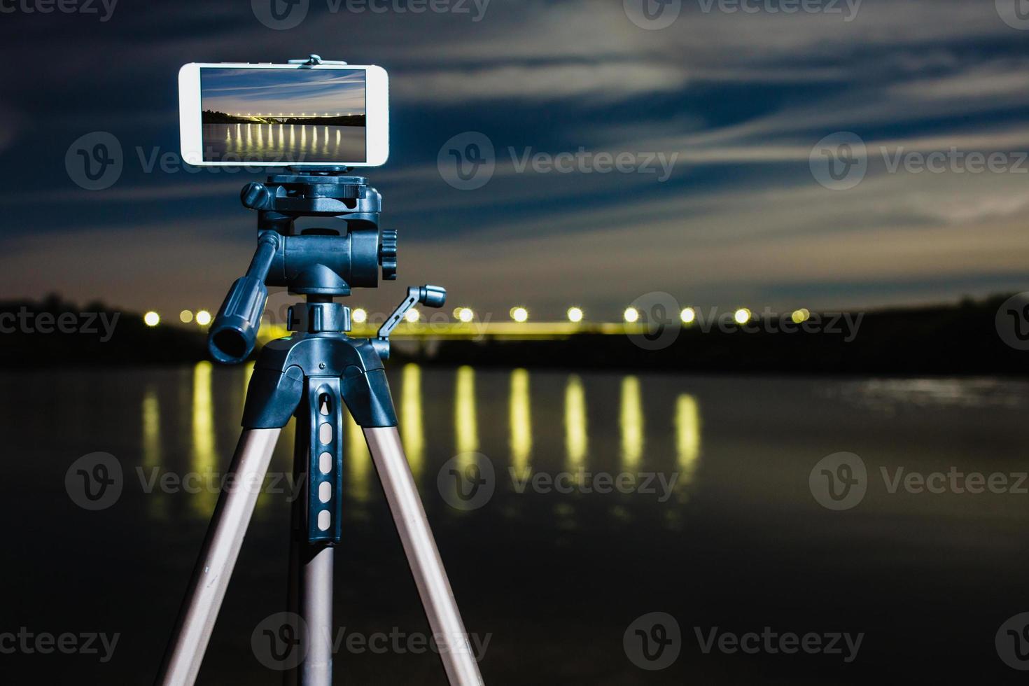 utilizzando lo smartphone come una fotocamera professionale su treppiede per catturare paesaggi notturni foto