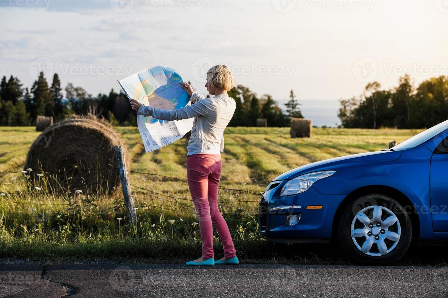 donna pensierosa su una scena rurale guardando una mappa foto