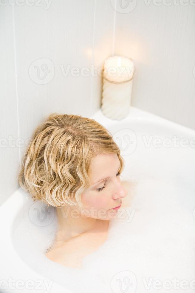 giovane donna che si rilassa nella vasca da bagno foto