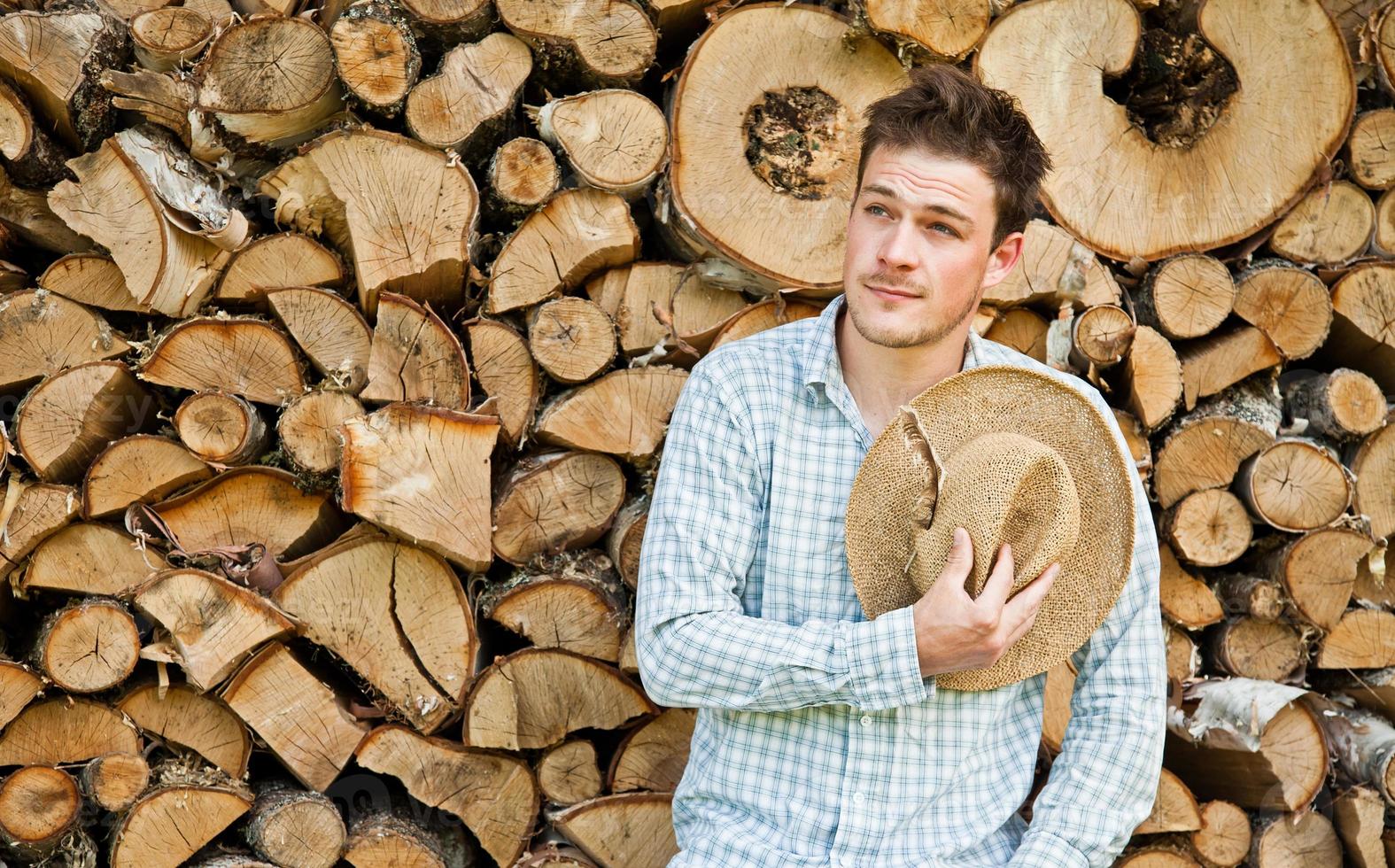 taglialegna con cappello di paglia su uno sfondo di legno foto