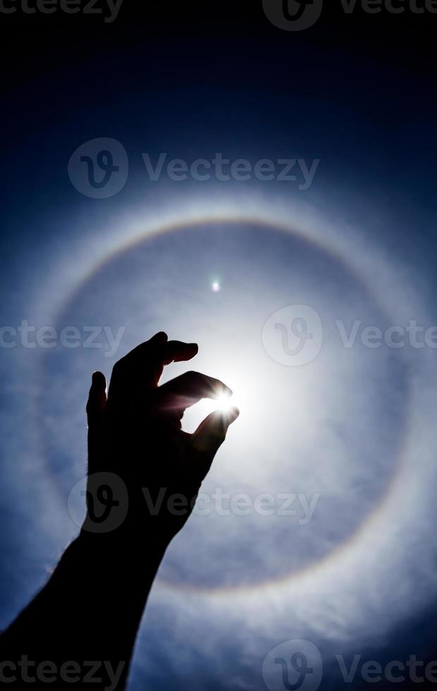 sagoma di una mano con aureola solare circolare foto