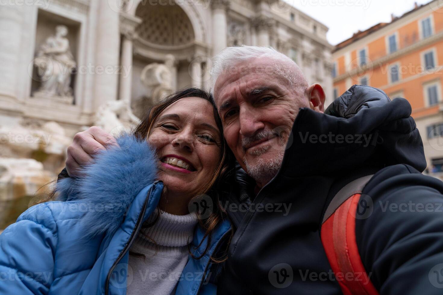 contento mezzo anziano coppia su vacanza assunzione un' autoscatto nel davanti di un' famoso trevi Fontana nel Roma foto