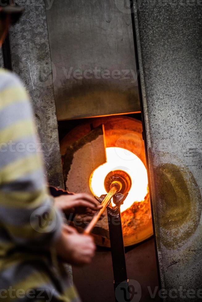 vetraio lampeggiante pezzo di vetro nel forno foto