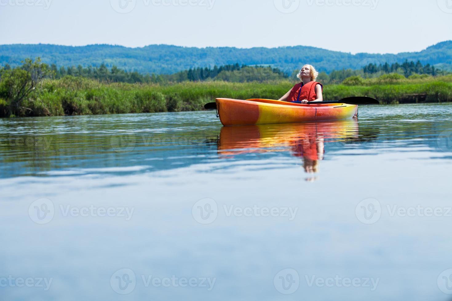 donna che si distende su un kayak e godersi la vita foto
