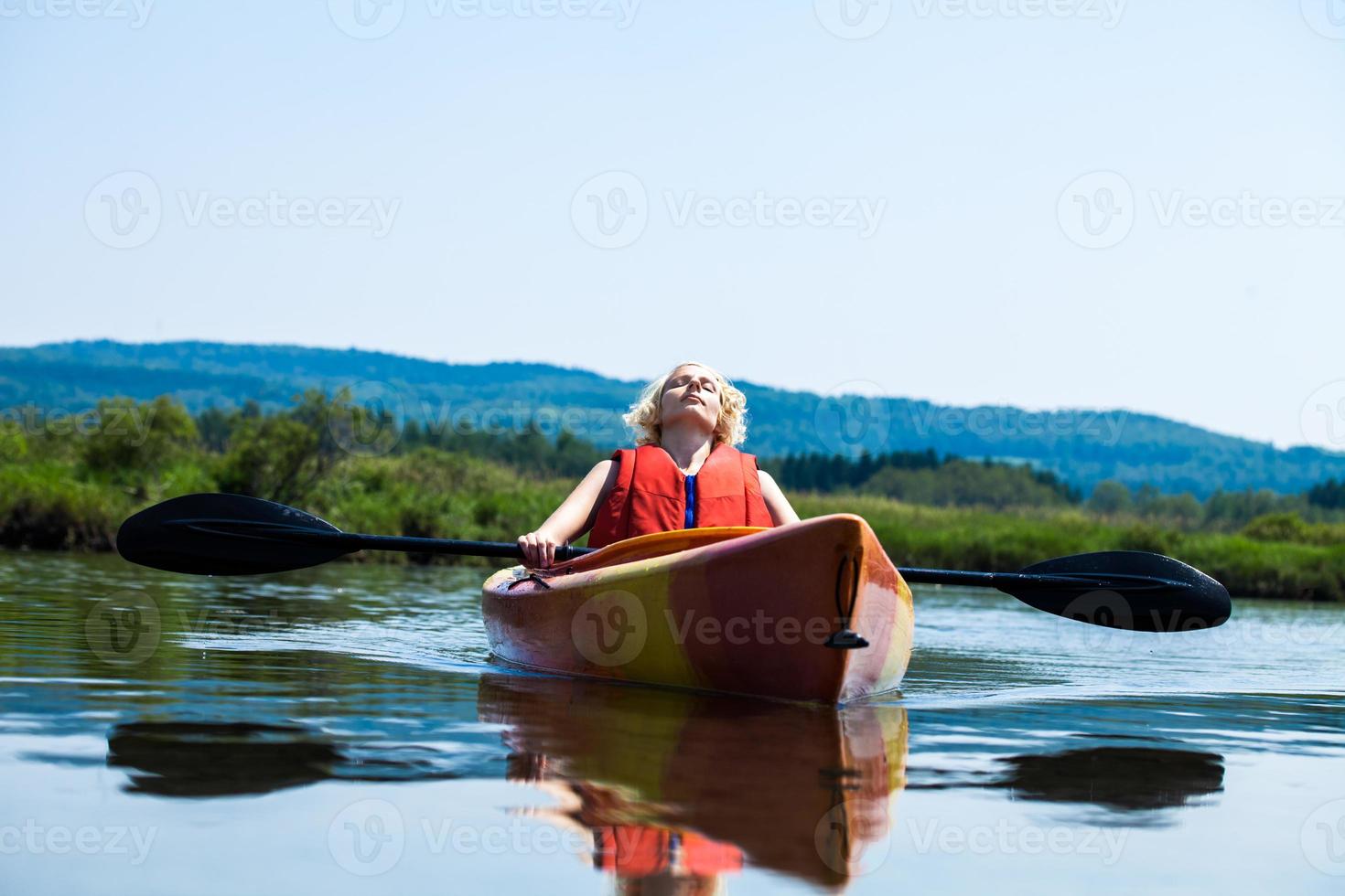 donna che si distende su un kayak e godersi la vita foto