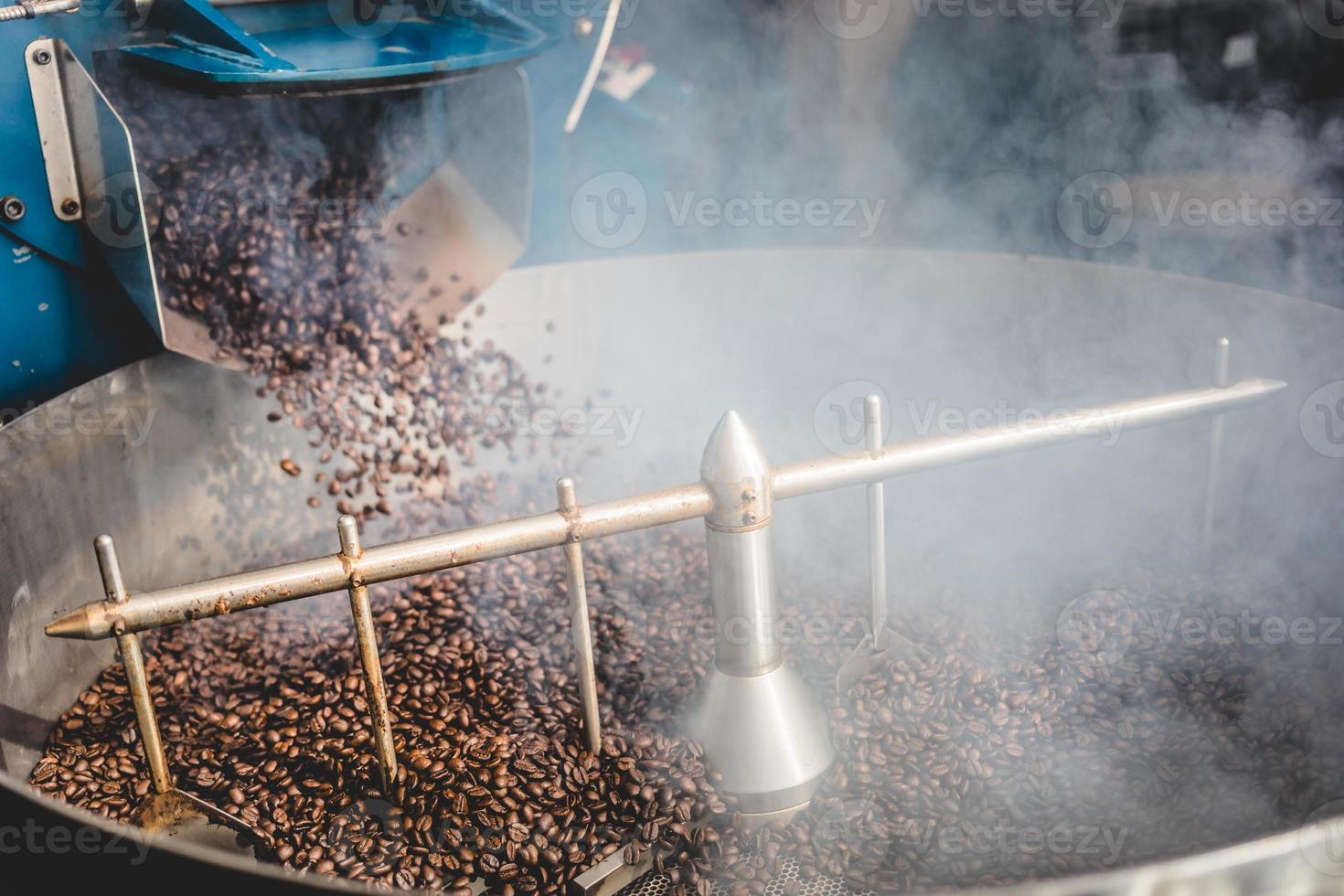 chicchi di caffè tostati fumanti nel cilindro di raffreddamento foto