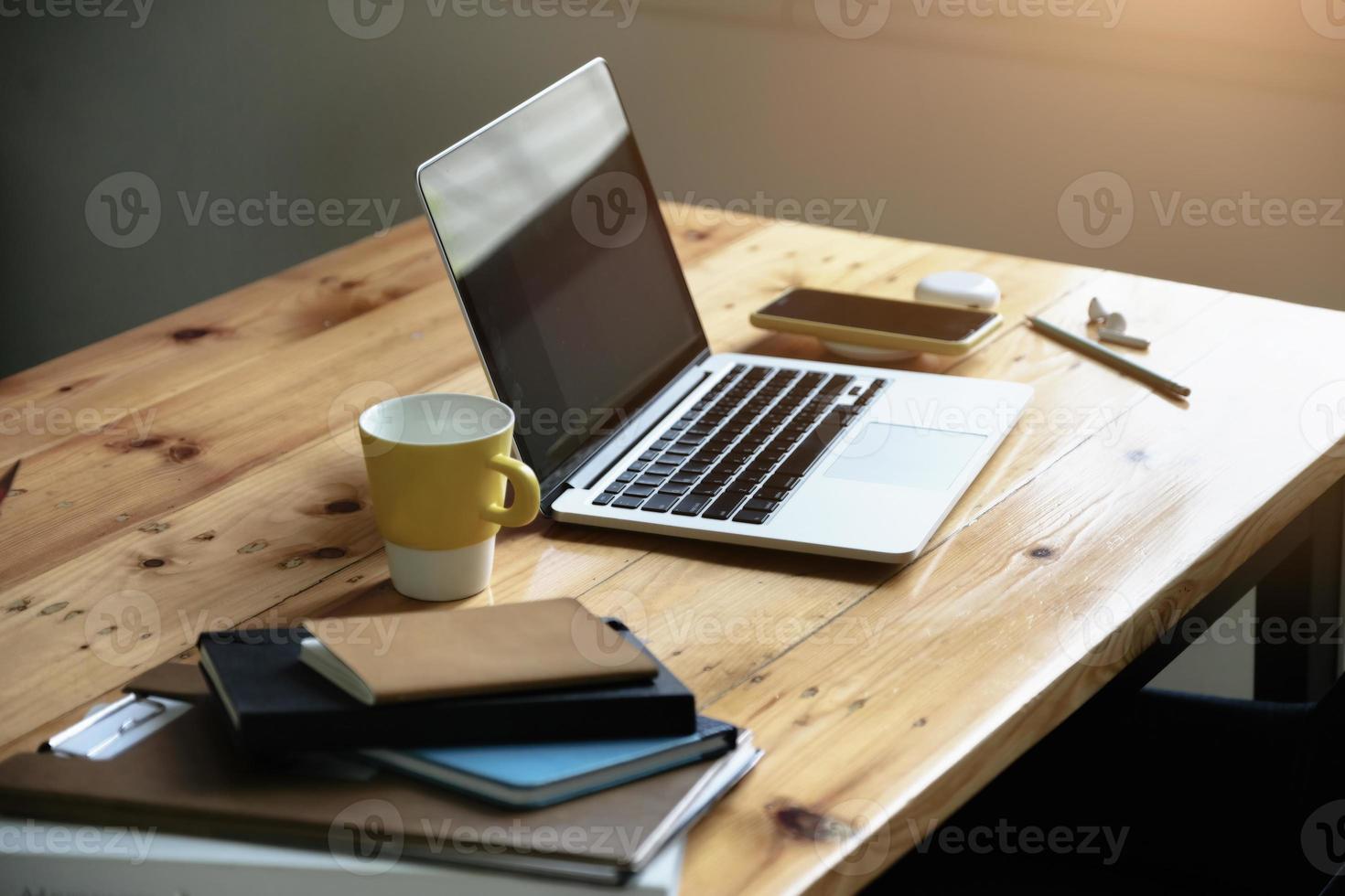 concetto di lavoro, computer, tazza da caffè, libri e documenti sulla scrivania. foto