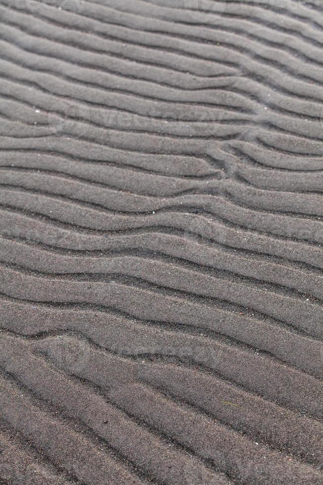 fila nella sabbia di una spiaggia creata dalla bassa marea foto