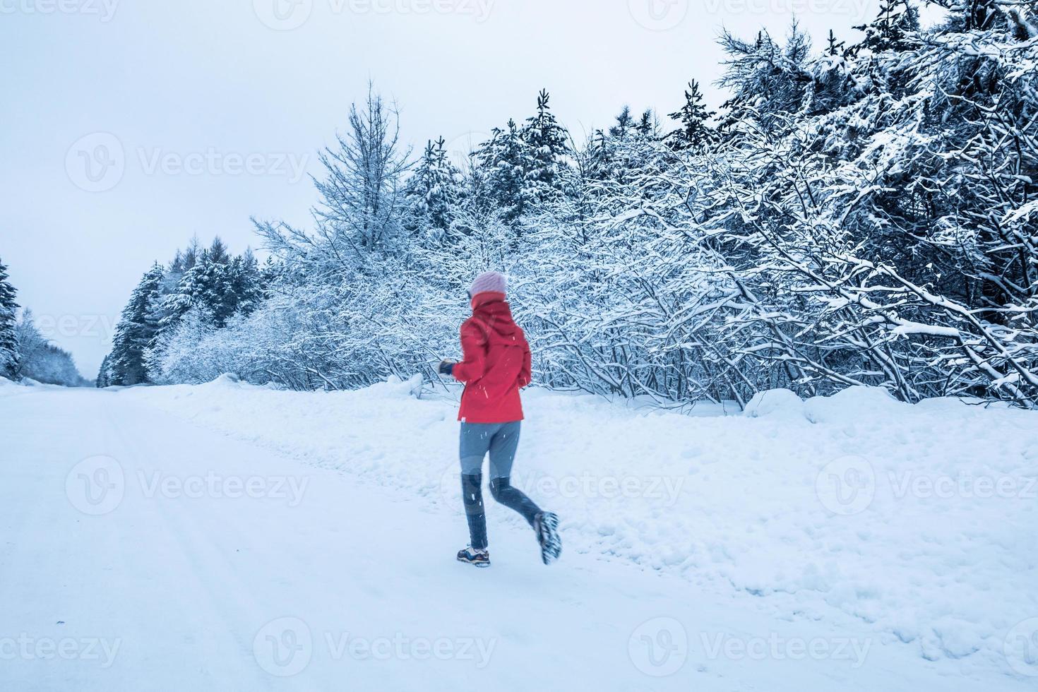 donna che corre da sola con motion blur durante il freddo giorno di neve invernale in canada foto