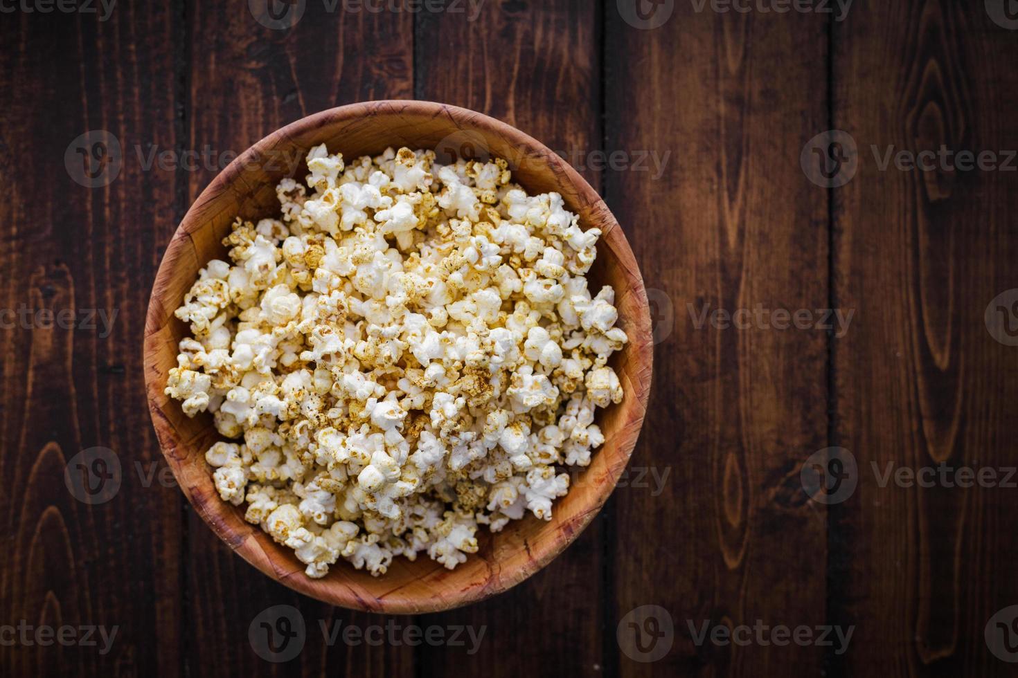 popcorn speziati in una ciotola di legno foto