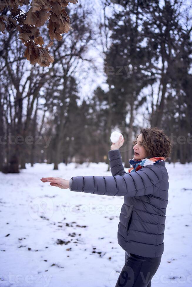 donna giocare con neve nel foresta foto