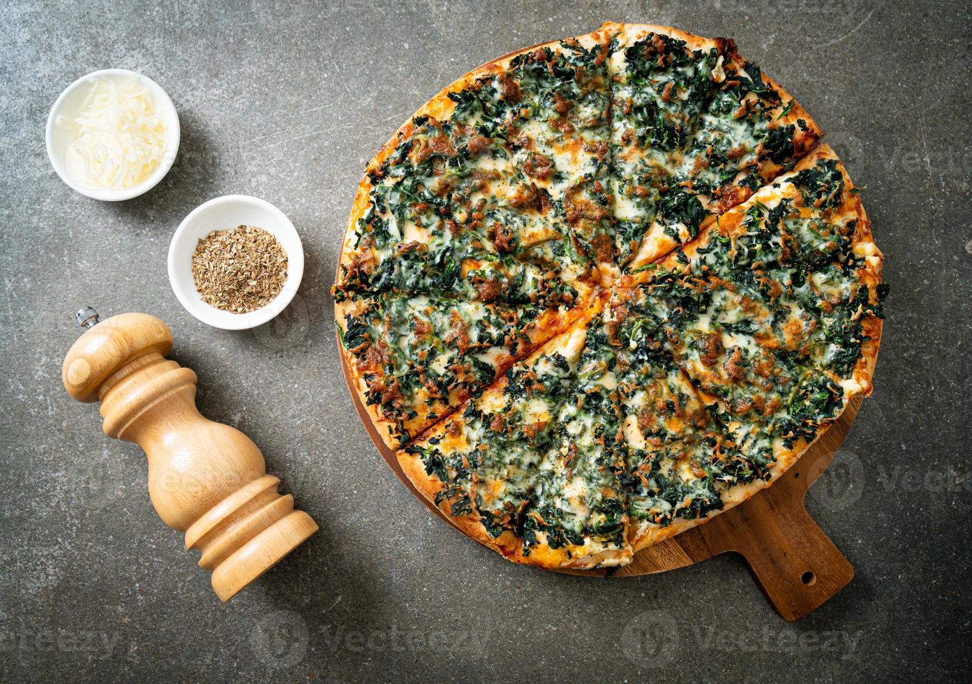 pizza spinaci e formaggio su teglia di legno foto