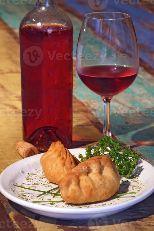 carne empanada, un' classico di argentino cucina accompagnato di vino foto