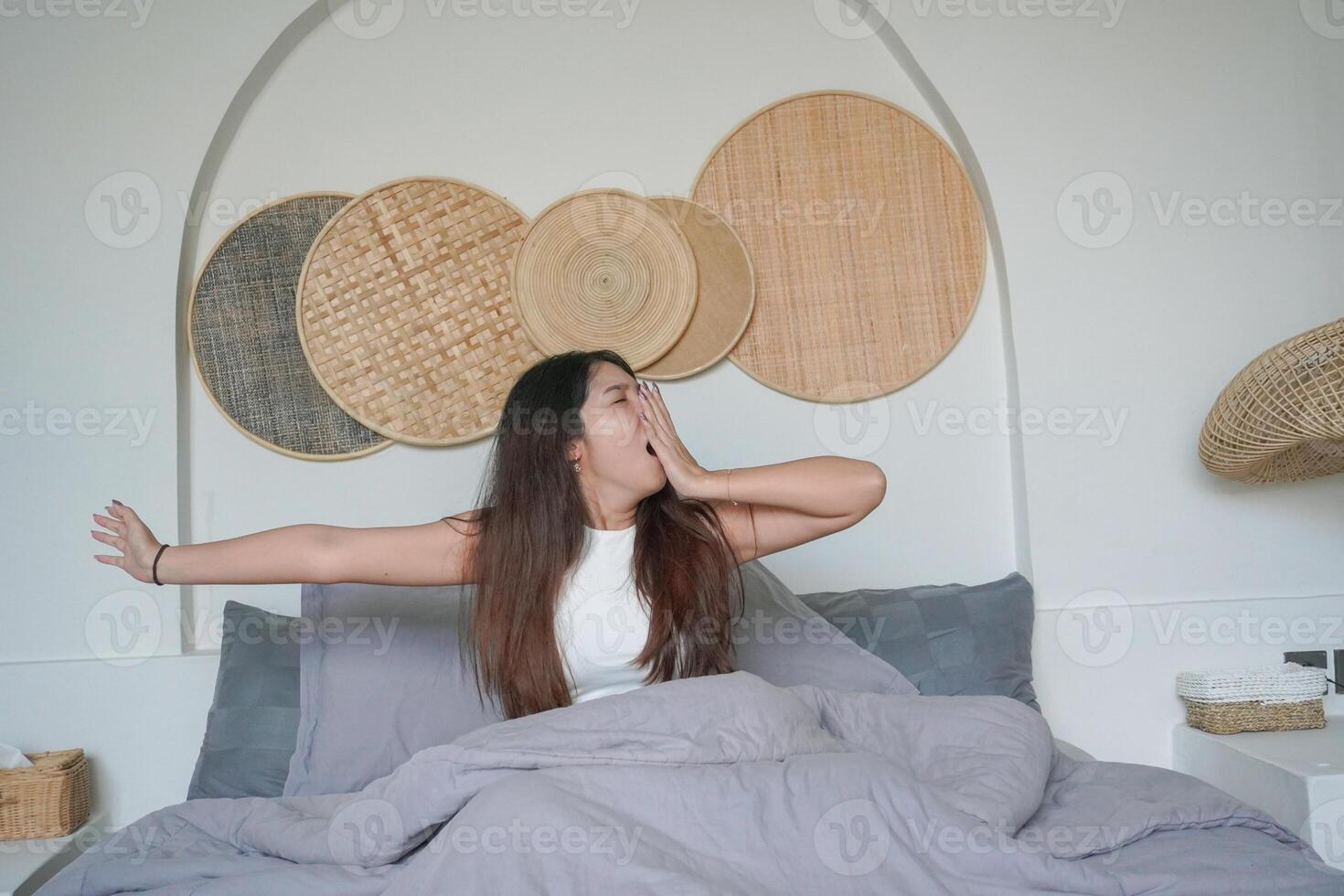 assonnato asiatico giovane donna sbadigli e raccolta mano veglia su nel presto mattina dopo in profondità dormire, tranquillo, calmo mattina vacanza concetto foto