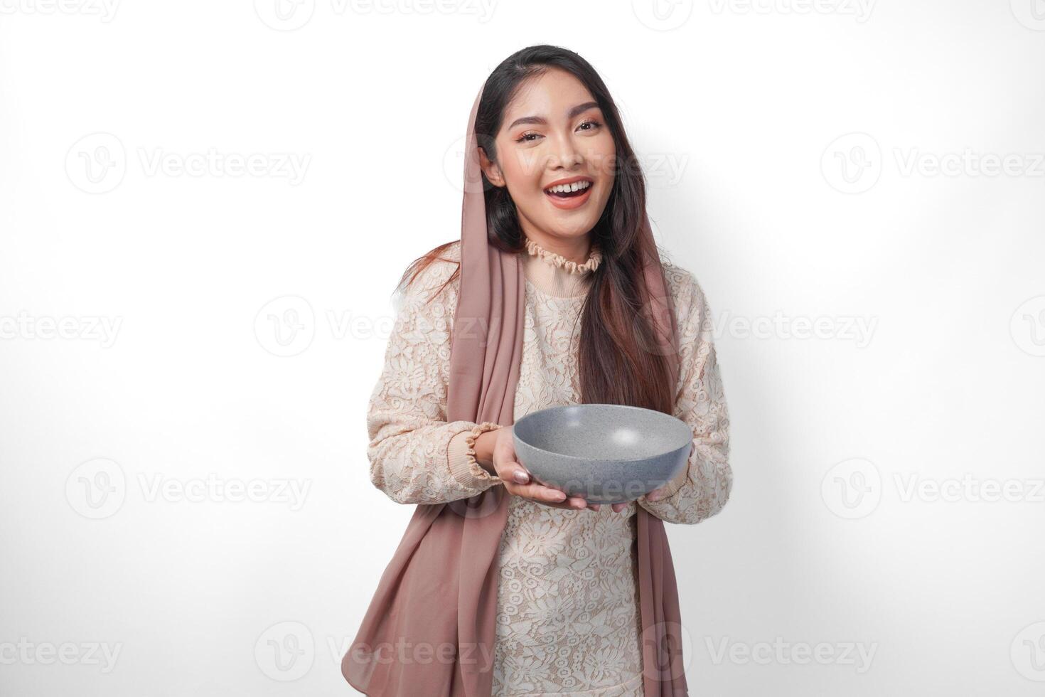 contento asiatico musulmano donna Tenere ciotola e posate per mangiare dopo digiuno mentre sorridente allegramente su isolato bianca sfondo. Ramadan concetto foto