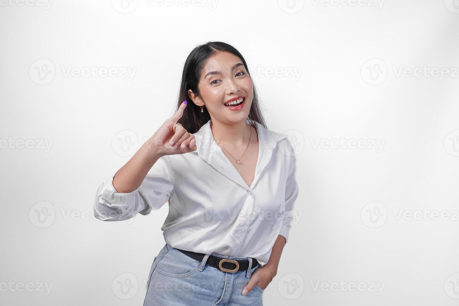 giovane asiatico donna con orgoglio mostrando poco dito immerso nel viola inchiostro dopo voto per Presidente e parlamento elezione, esprimendo eccitazione e felicità foto