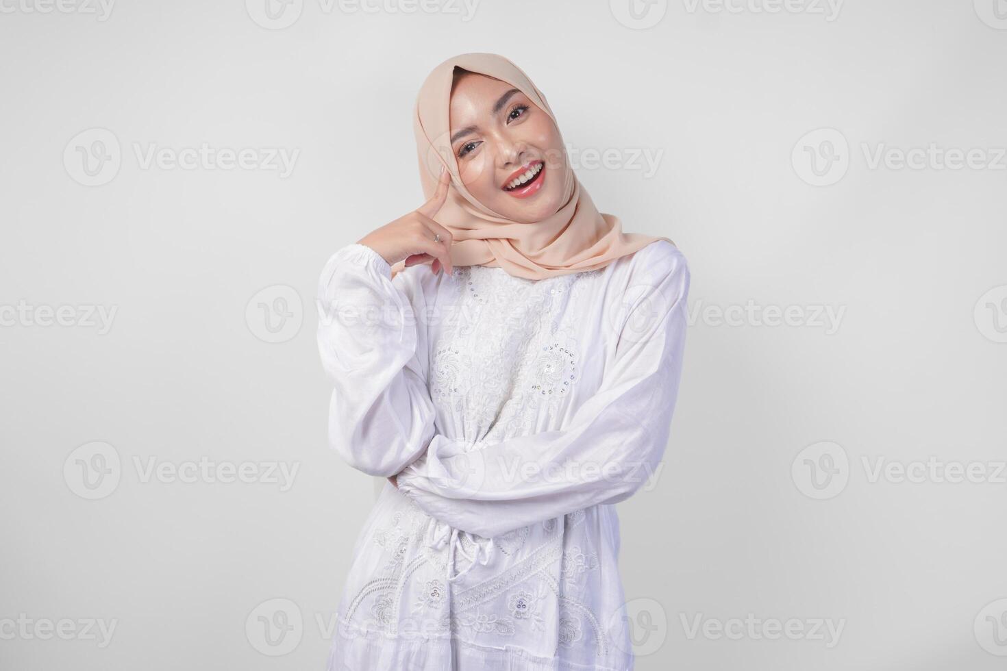 riflessivo giovane asiatico musulmano donna indossare bianca vestito e hijab pensiero e scoperta idea con contento espressione, isolato su bianca sfondo foto