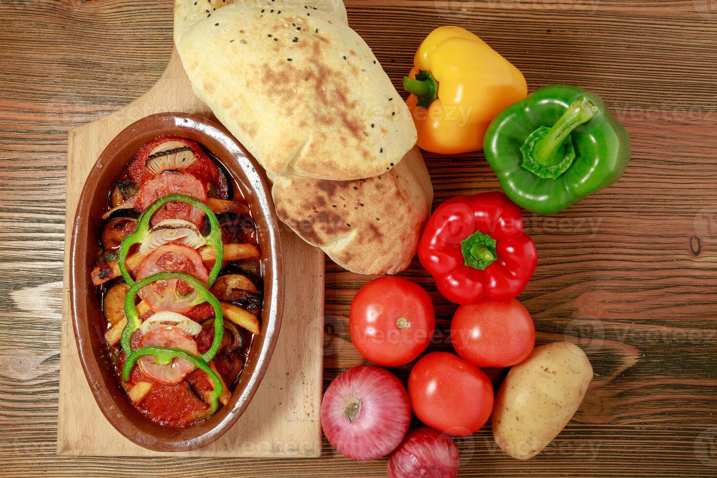 moussaka con Patata. pomodoro, campana Pepe, cipolla e Pita pane servito nel di legno tavola isolato su tavolo superiore Visualizza di Arabo cibo foto