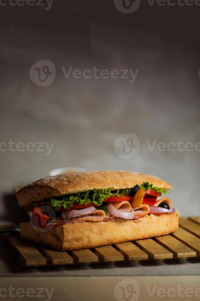 Ciabatta affumicato prosciutto Sandwich isolato su di legno con Maionese tuffo e francese patatine fritte secchio tavola lato Visualizza di italiano veloce cibo su grigio sfondo foto