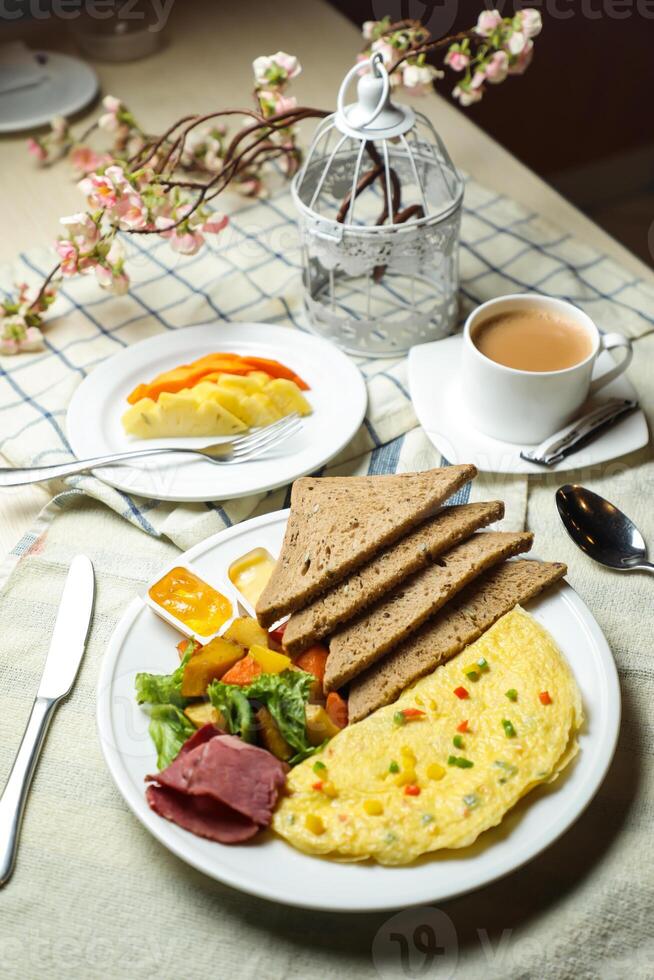 ripieno frittata con Bown pane, carne, verdura insalata includere pomodoro, Patata, lattuga foglia e carota con Tè, caffè, e dolce melone servito su cibo tavolo superiore Visualizza salutare prima colazione foto