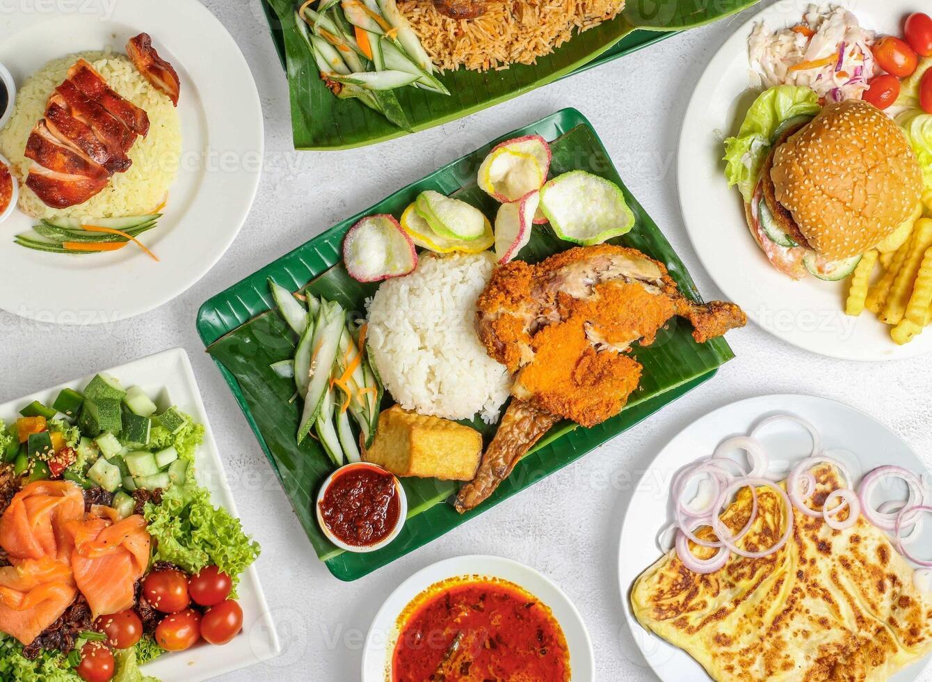 ayam pentito, carbonizzare vista pollo Riso, salmone colpire ciotola, pollo biryani, uovo cipolla parata, Manzo hamburger, francese patatine fritte e insalata servito nel piatto isolato su Banana foglia superiore Visualizza Singapore cibo varietà foto