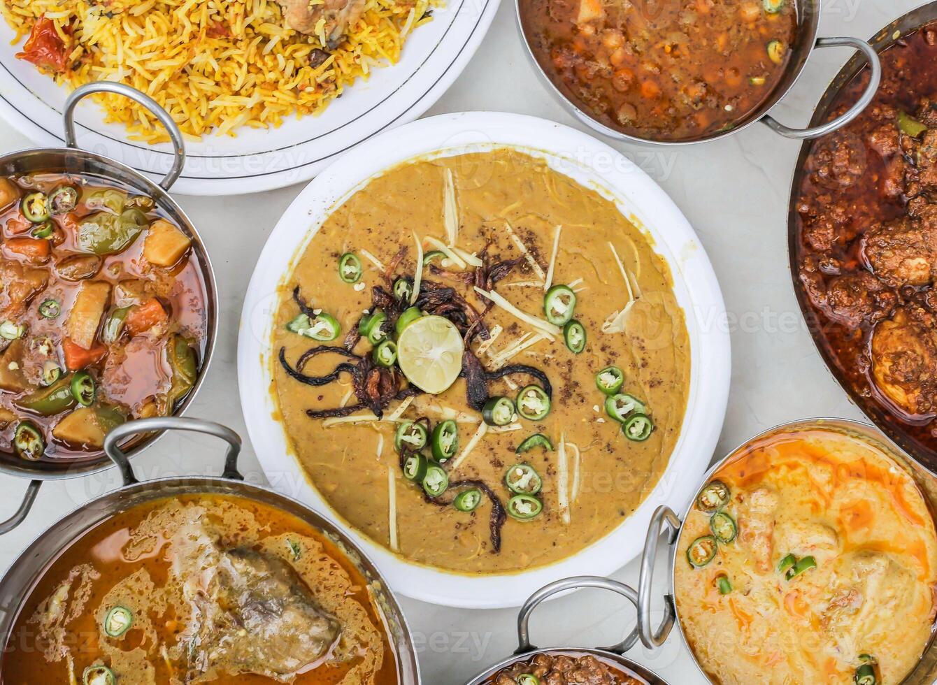 pollo haleem, pollo karahi, biryani, Manzo Nihari, curry pakora, Chanay, aloo shimla mirch e keema isolato su grigio sfondo superiore Visualizza di pakistano e assortito indiano spezie cibo varietà foto