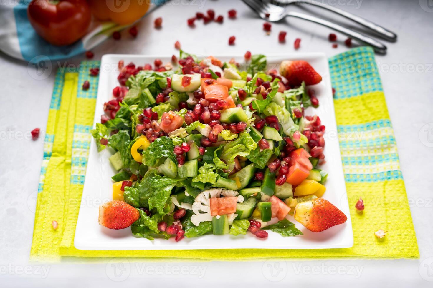 Melograno insalata con fragola, cetriolo, pomodoro, cavolfiore e verde le foglie servito nel piatto isolato su tavolo superiore Visualizza di Arabo cibo foto