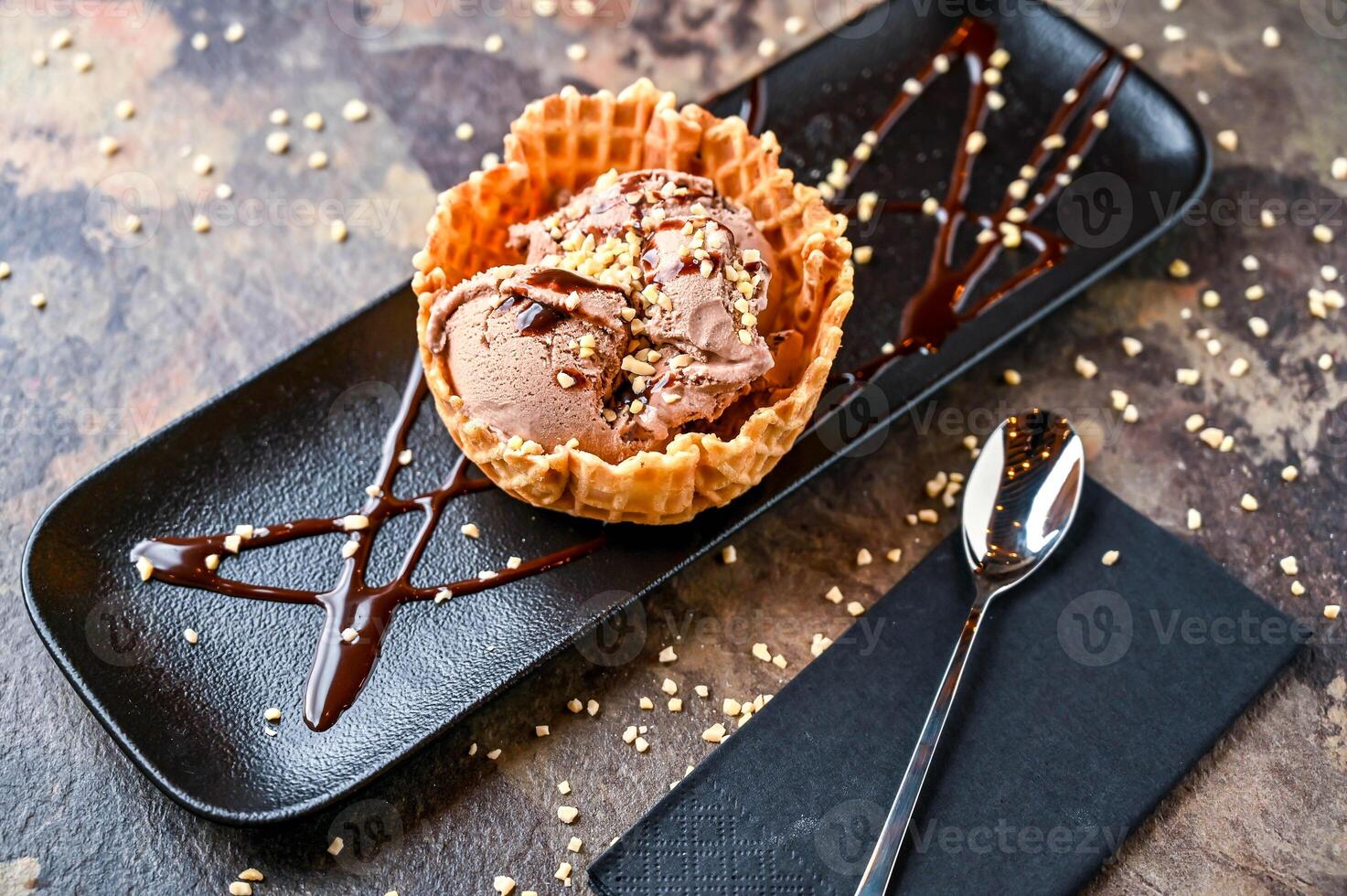 ferro Rocher gelato con ghiaccio crema, bianca cioccolato patata fritta, e cucchiaio servito nel cono isolato su buio sfondo avvicinamento superiore Visualizza di bar al forno dolce cibo foto