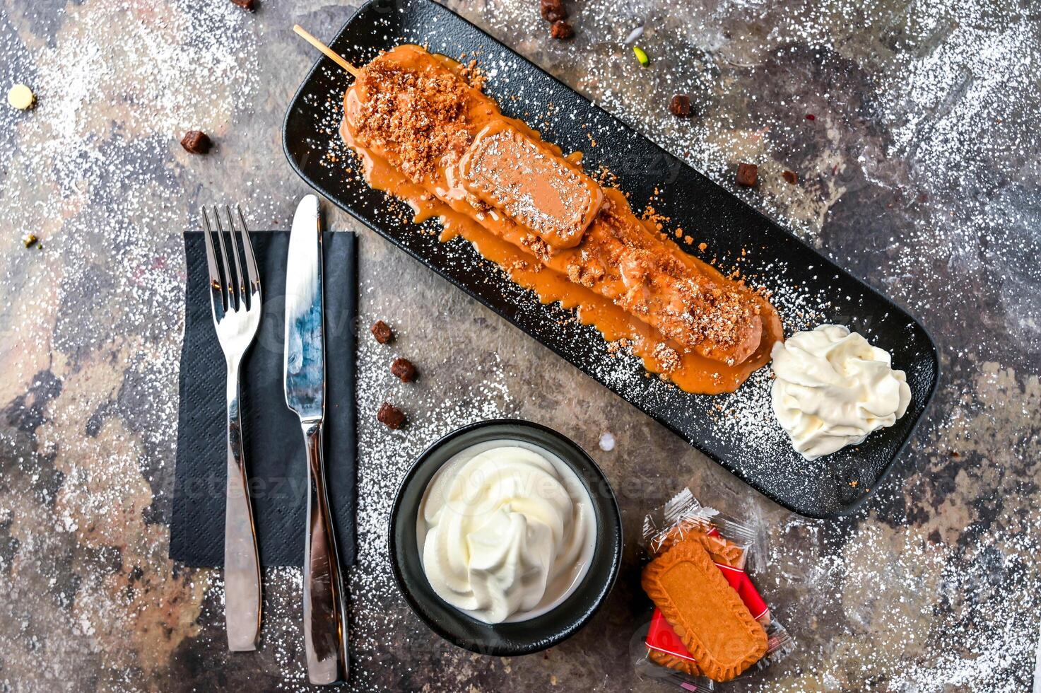 loto cialda bastone con cioccolato, frustato crema, coltello e forchetta servito nel piatto isolato su buio sfondo superiore Visualizza bar dolce cibo foto