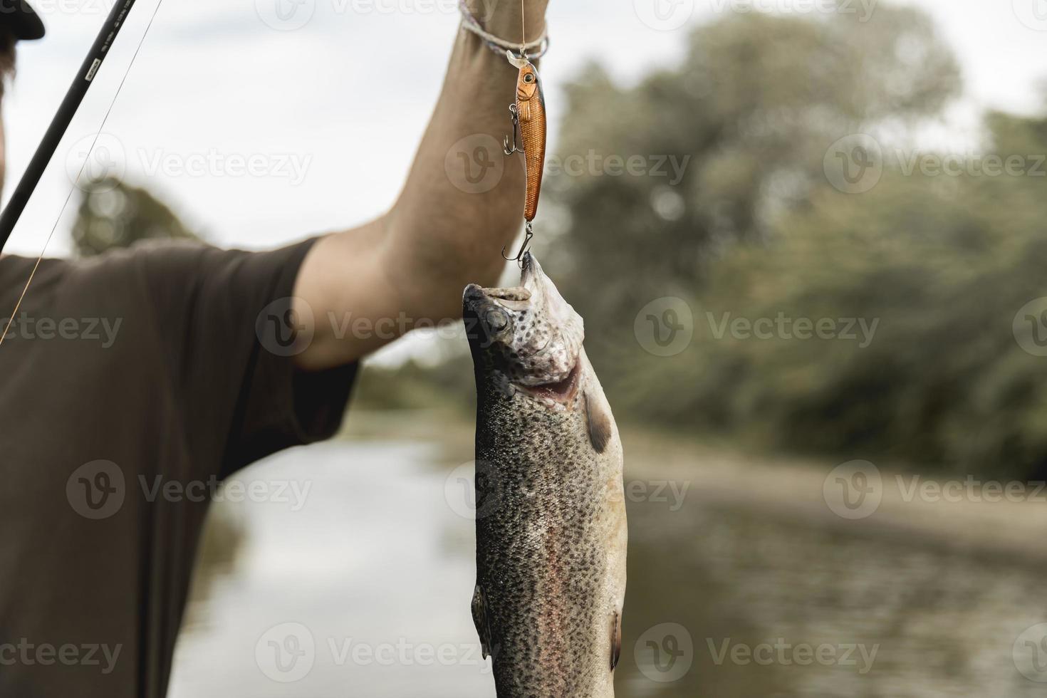 persona che pesca il pesce con la canna foto