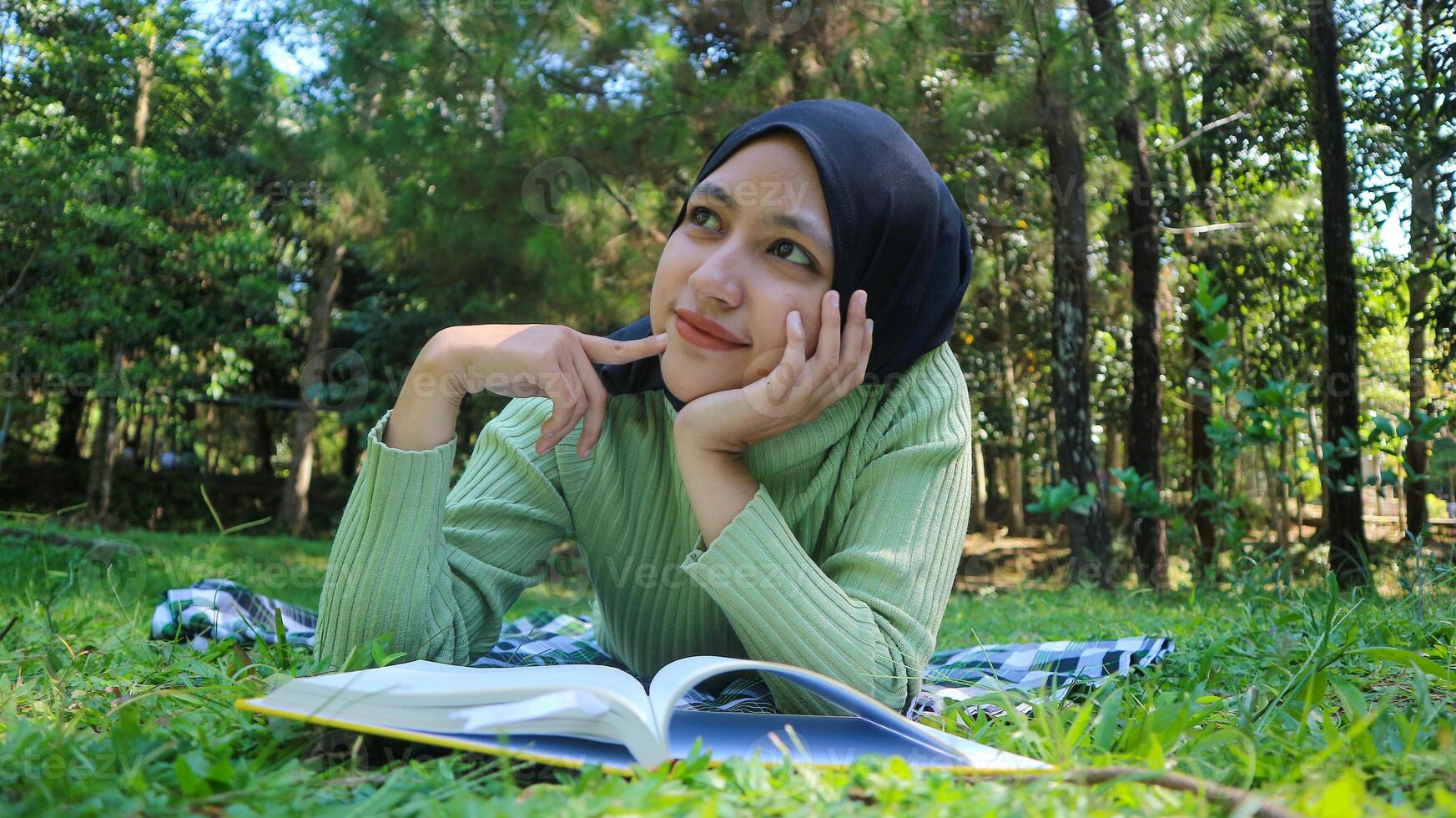 sorridente musulmano donna nel hijab nel parco Tenere libro e penna pensiero idea.vuoto spazio foto