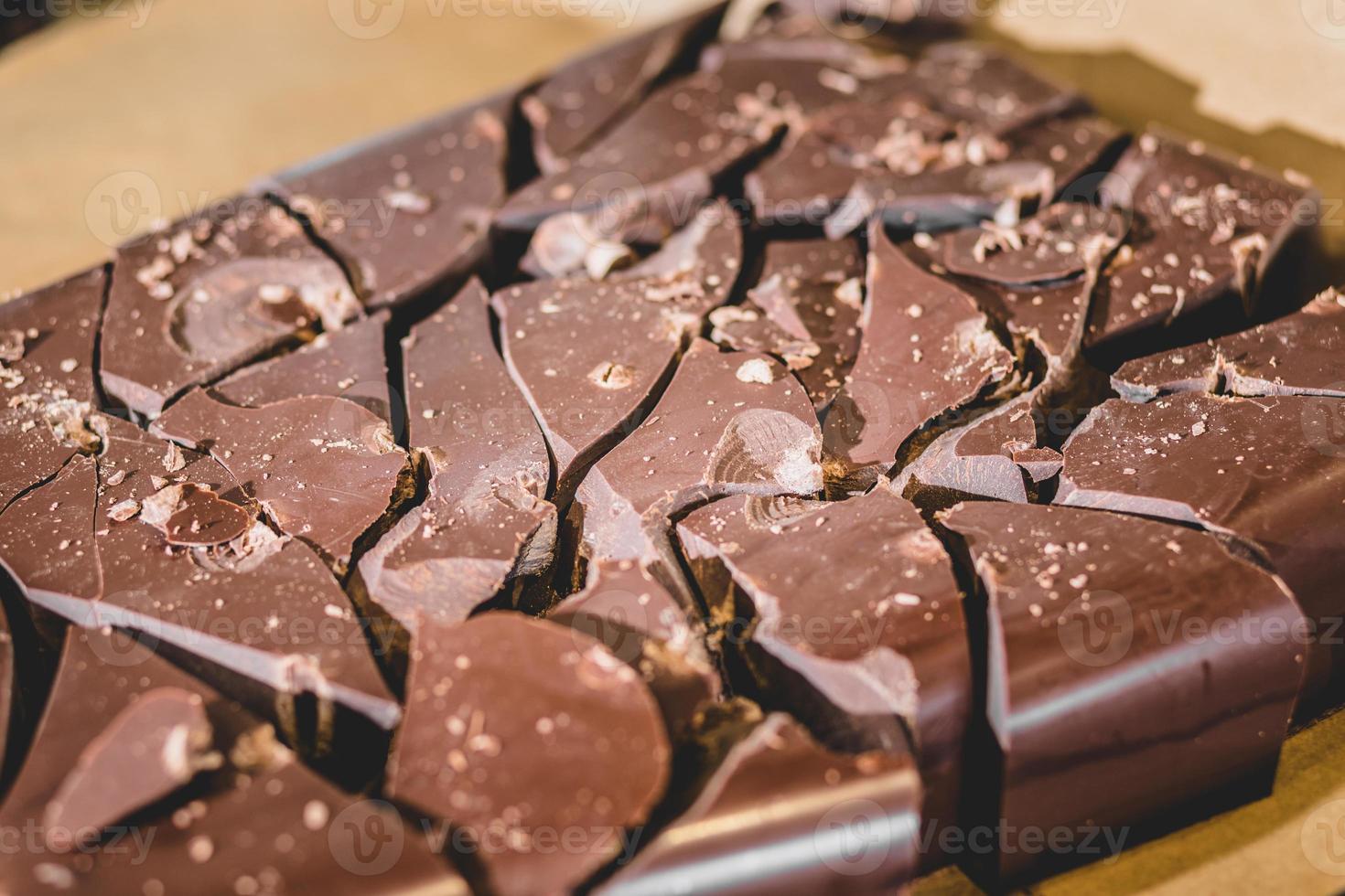 grande blocco di cioccolato spezzato a pezzi foto