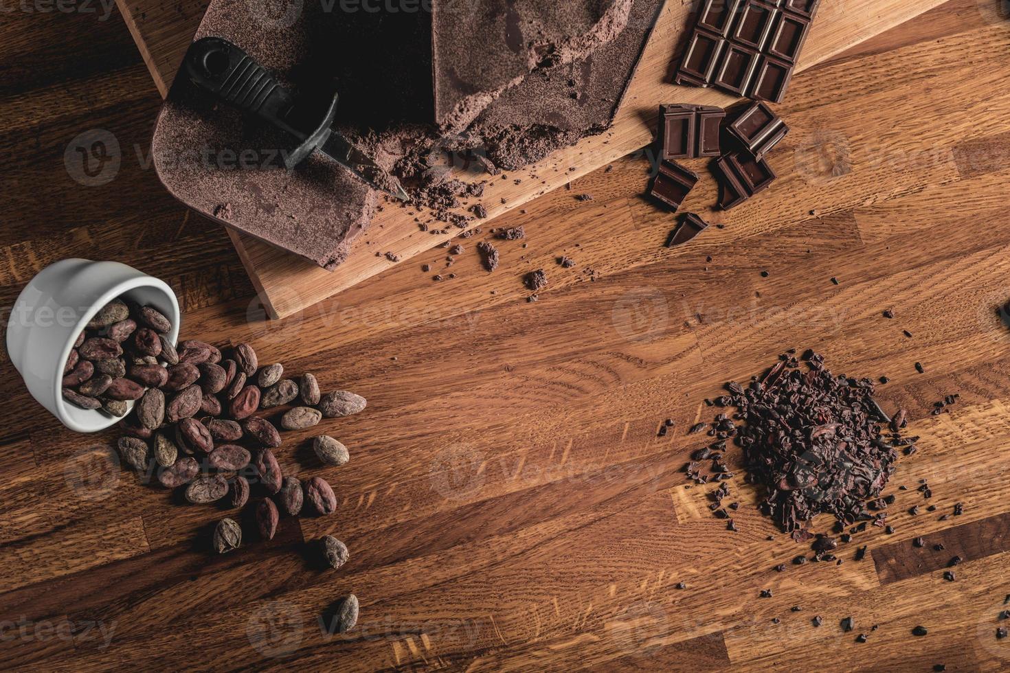 dolce vista dall'alto disposizione di fave di cacao, pennini e barrette di cioccolato foto