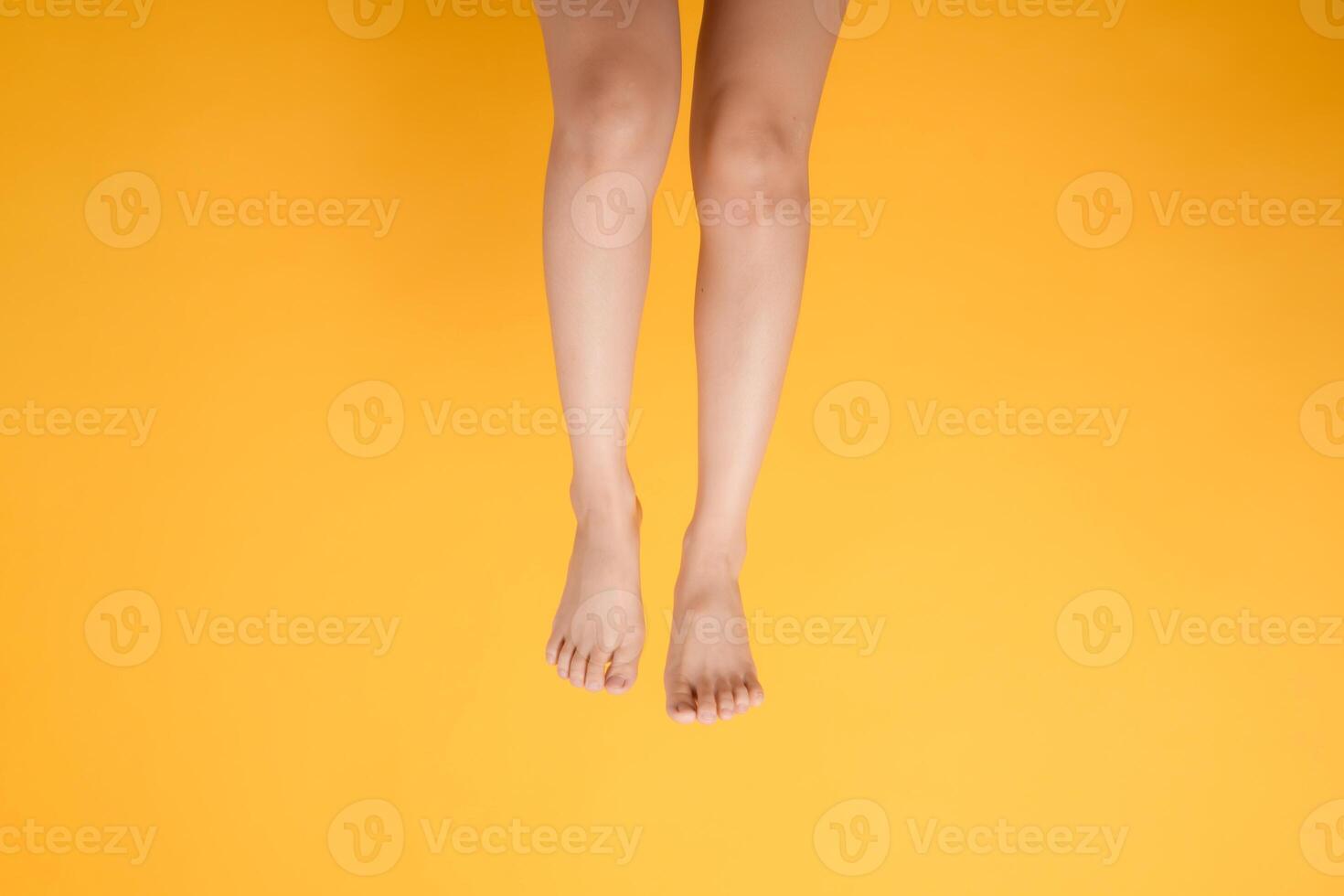 delizioso toccare di eleganza attraverso un' 30s di persona vicino su, con vellutato piede toccare su un' vivace giallo sfondo. foto
