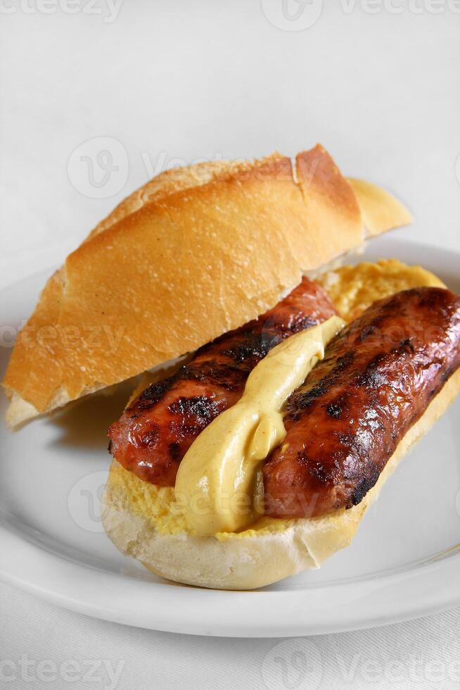 choripan, calabrese salsiccia Sandwich con mostarda su francese pane foto