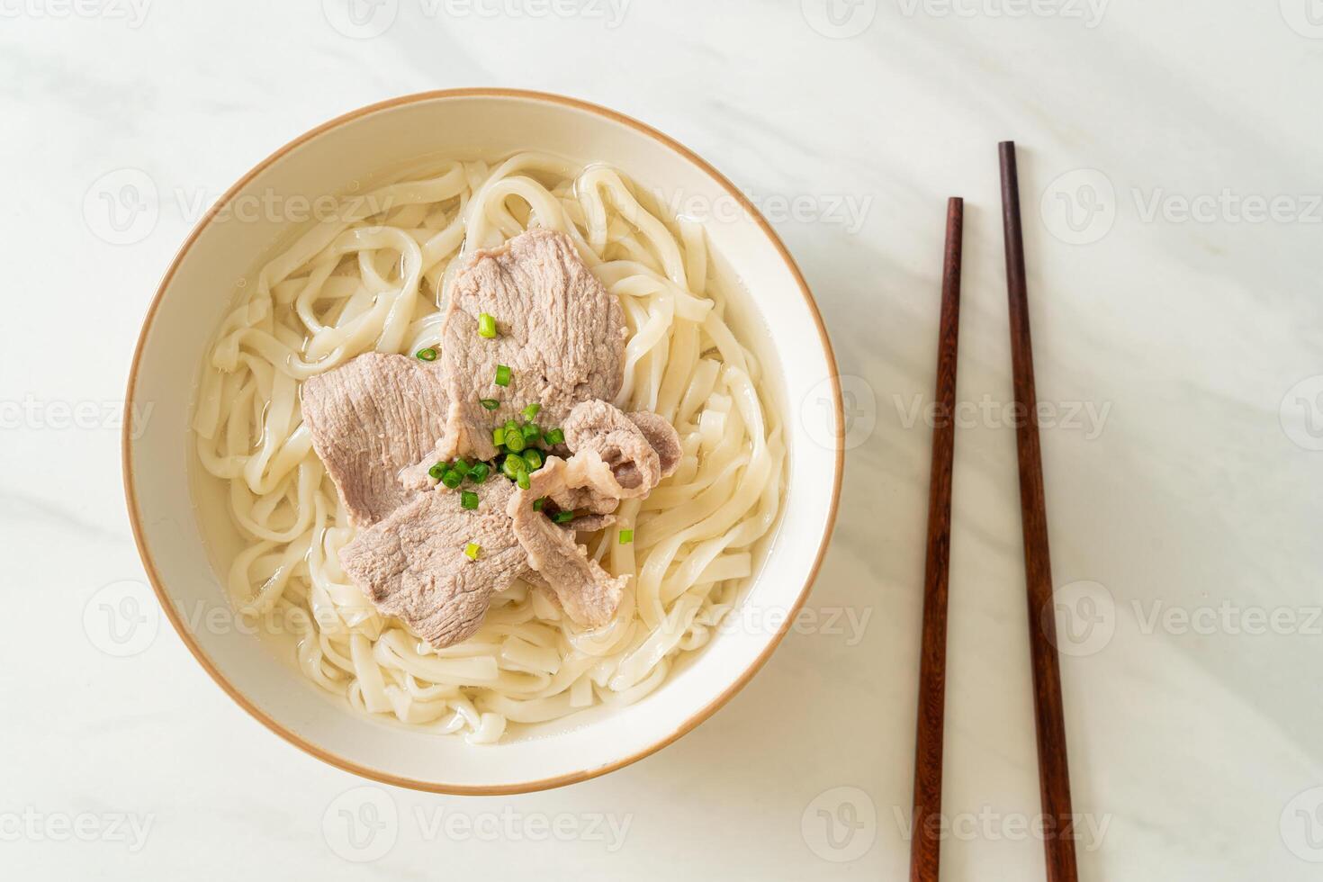 udon noodles con maiale in zuppa chiara foto