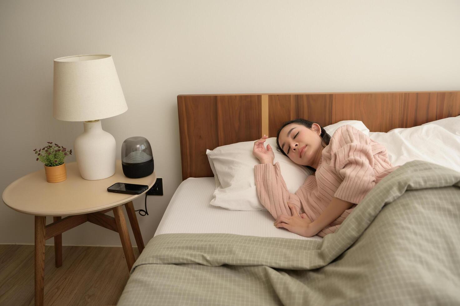 giovane asiatico donna addormentato nel il letto nel Camera da letto a casa foto