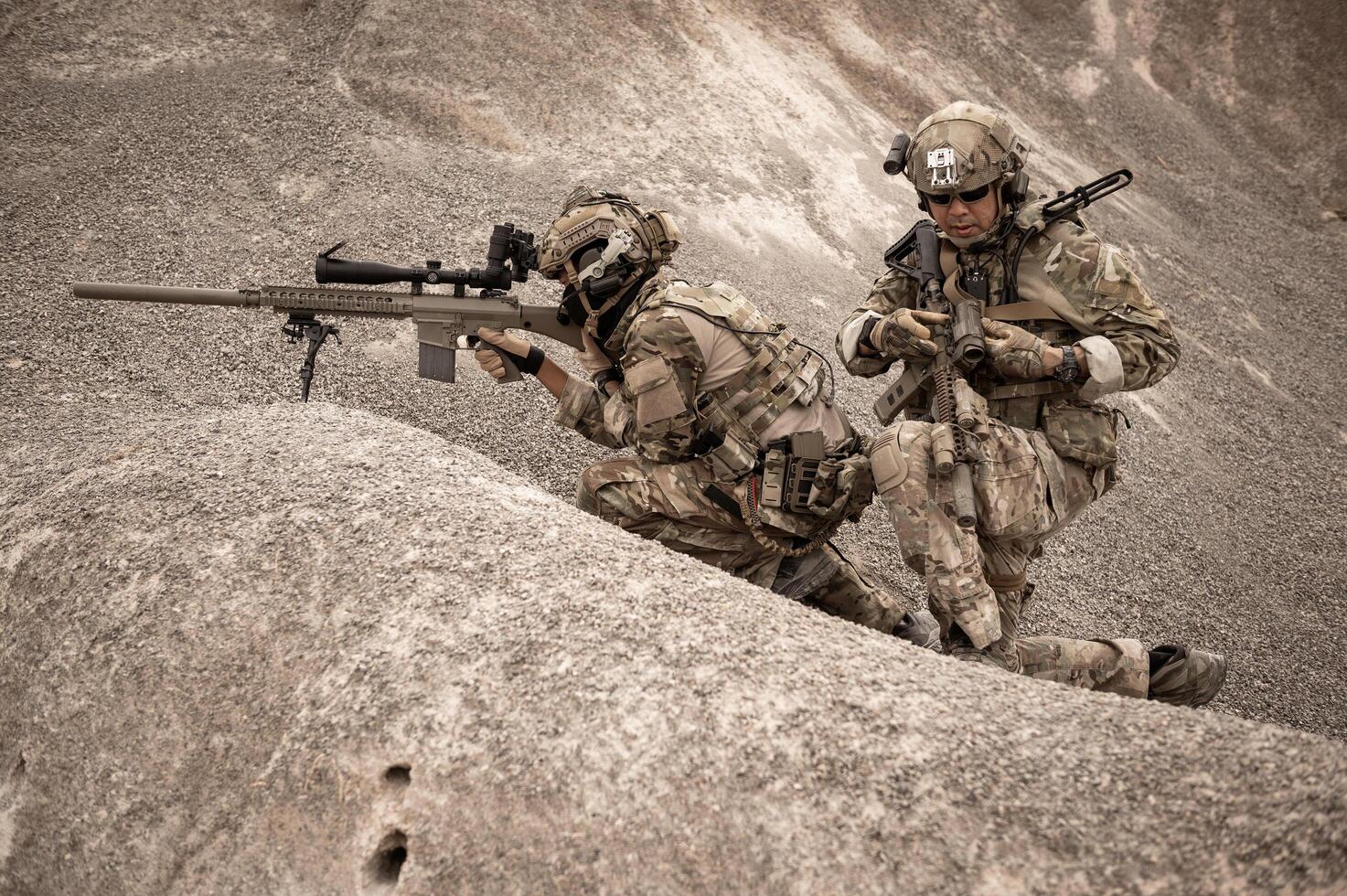 soldati nel camuffare uniformi mirando con loro fucili pronti per fuoco durante militare operazione nel il deserto soldati formazione nel un' militare operazione foto