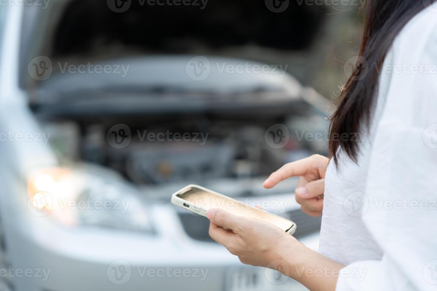 guasto, rotto macchina, riparazione. donna usi mobile Telefono dai un'occhiata assicurazione premi attraverso applicazione dovuto per auto incidente . trova box auto per ottenere auto fisso durante nazione tour, in attesa per aiuto, emergenza. foto