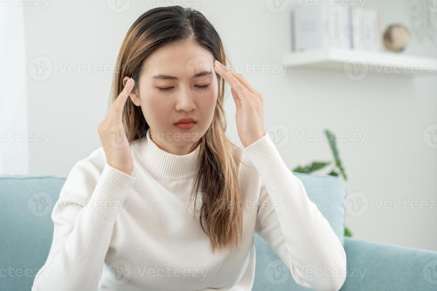 male alla testa, femmina avendo emicrania dolore, cattivo Salute, asiatico donna sensazione fatica e male alla testa, ufficio sindrome, triste stanco toccante fronte avendo emicrania o depressione, irritata ragazza, tristezza dolore foto