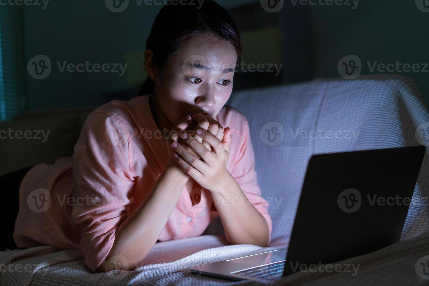 foto di giovane asiatico donna utilizzando il computer portatile nel il buio a mezzanotte