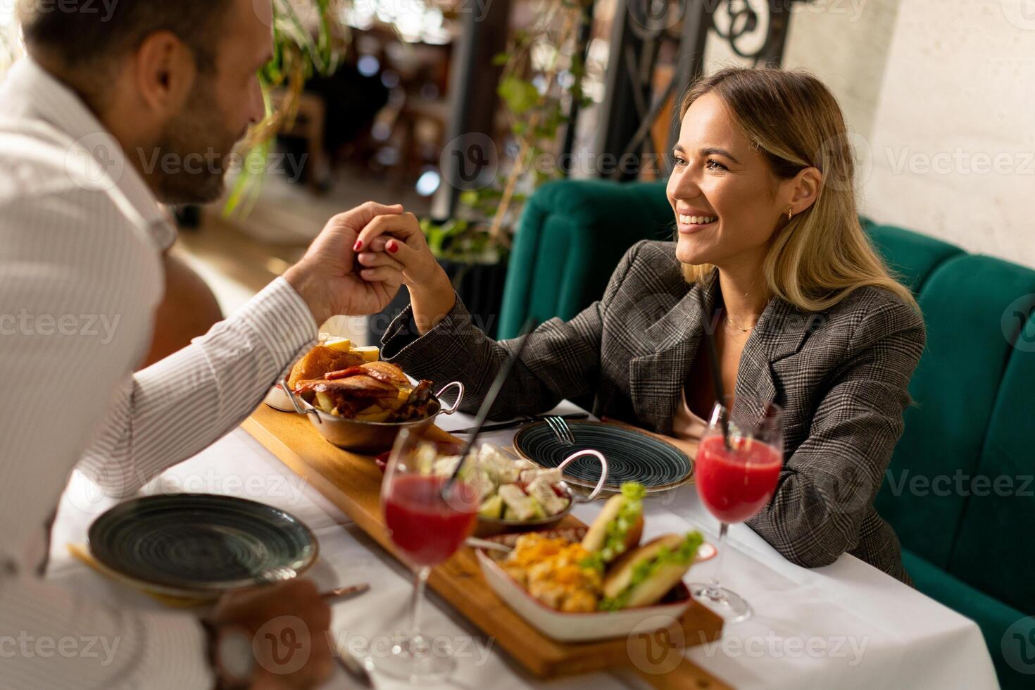 giovane coppia avendo pranzo e potabile fresco spremuto succo nel il ristorante foto