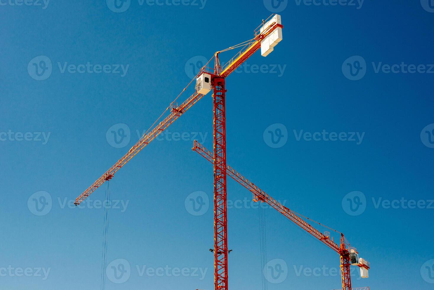 giallo industriale gru Lavorando su costruzione luogo contro blu cielo foto