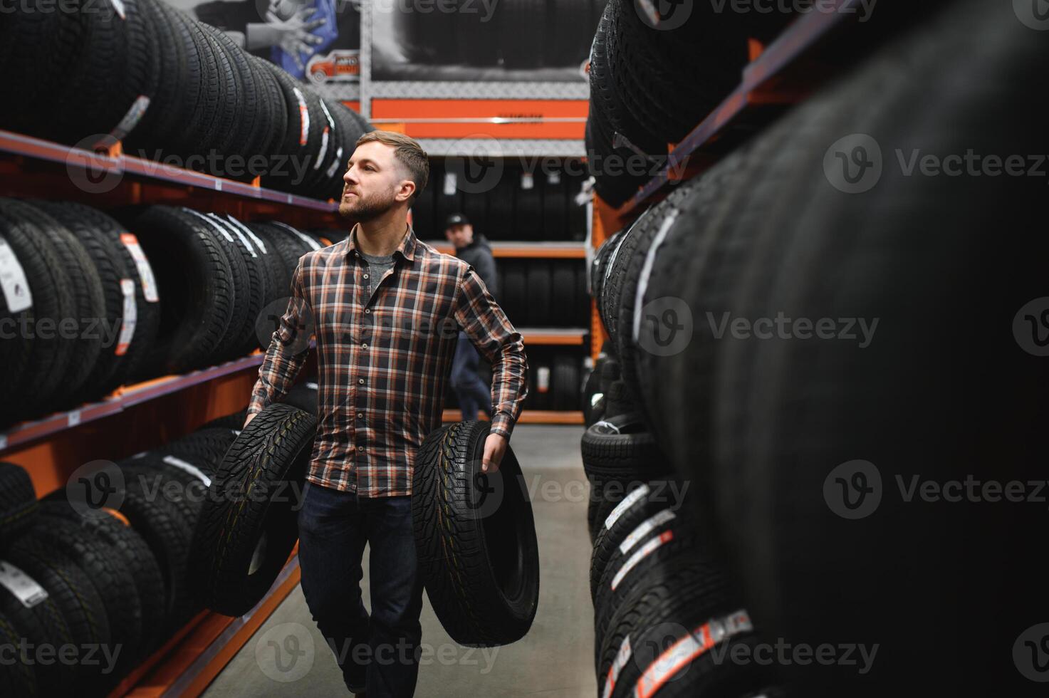 lieto maschio cliente assunzione nuovo pneumatici nel il supermercato per acquisto. lui sembra contento. grande shopping centro commerciale con auto merce foto