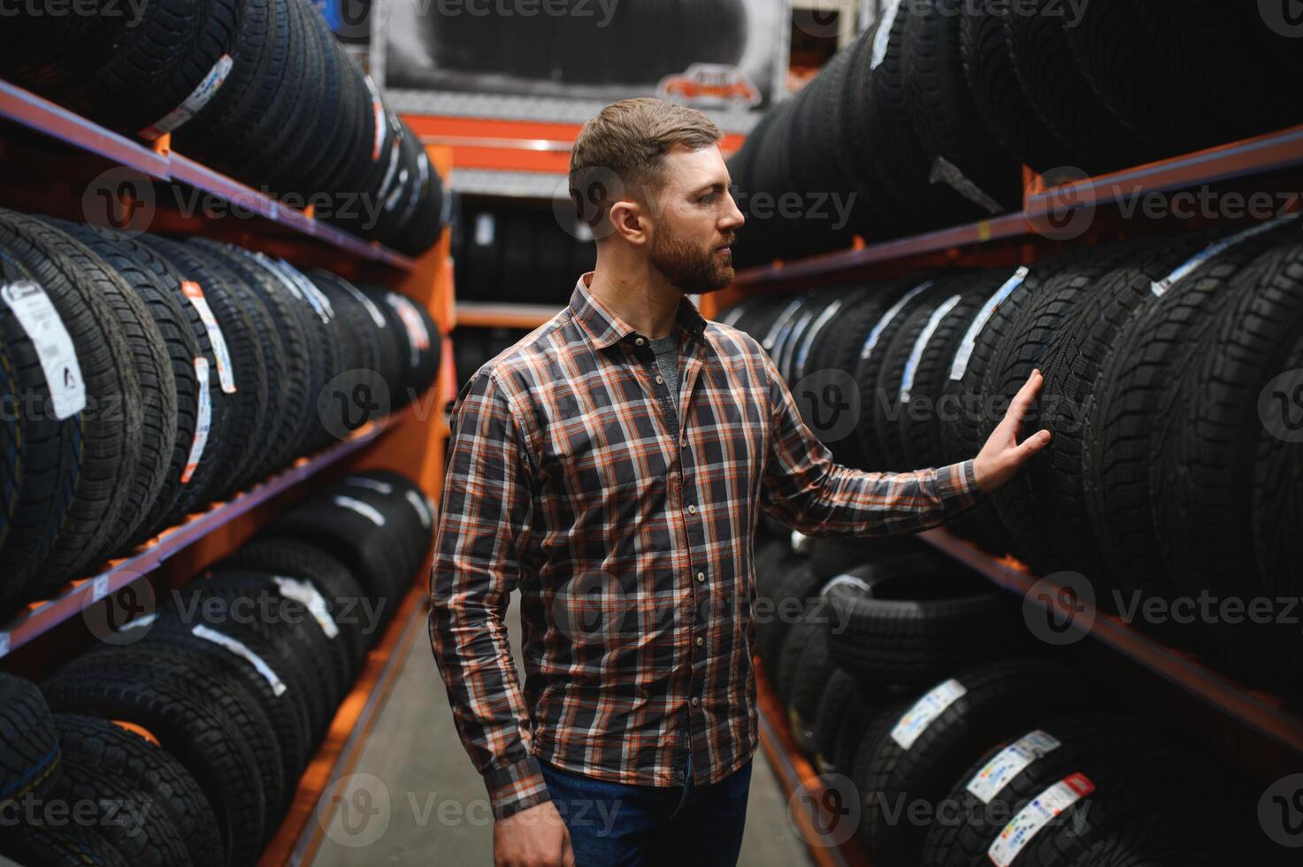 maschio meccanico con auto pneumatici nel automobile servizio centro foto